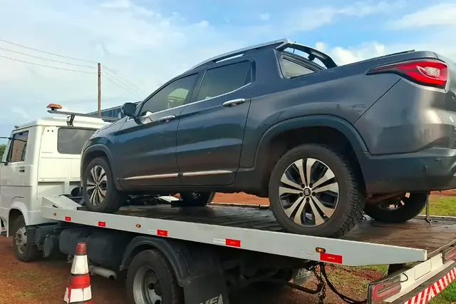 Picape cinza transportada no guincho plataforma